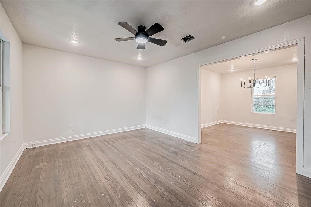 7010 South Hall Street Houston, TX 77028 - Photo 6 of 33 an empty room with wooden floor and a ceiling fan