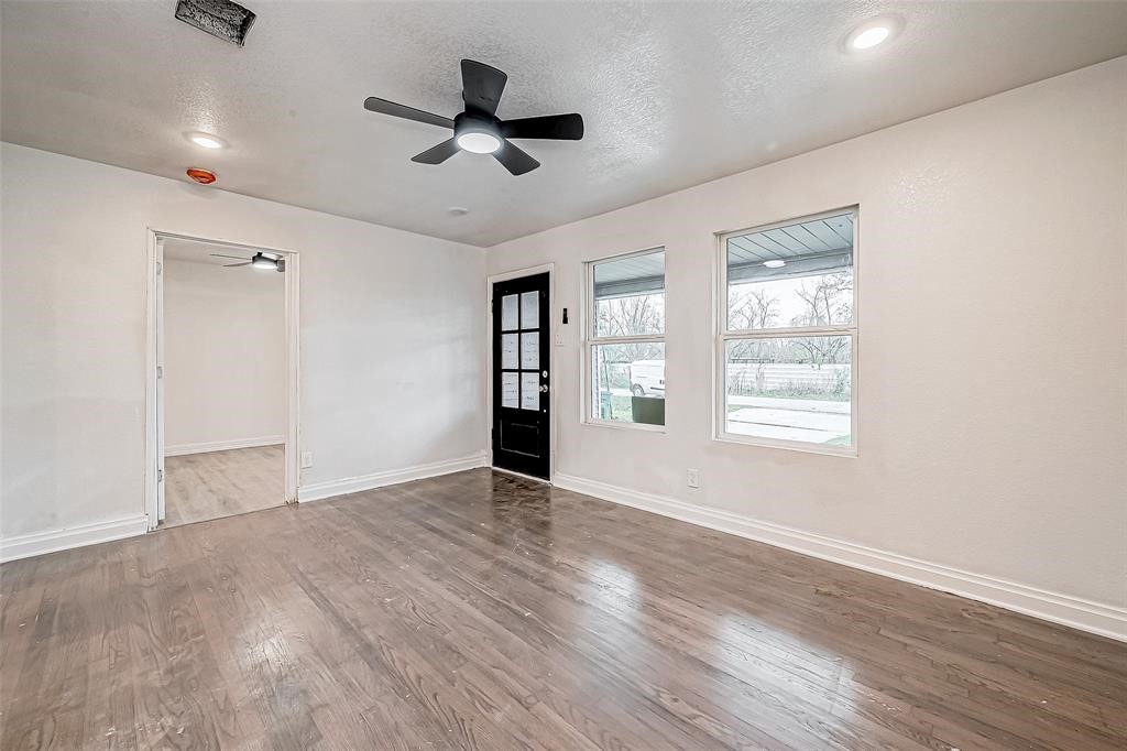 7010 South Hall Street Houston, TX 77028 - Photo 8 of 33 an empty room with wooden floor fan and windows
