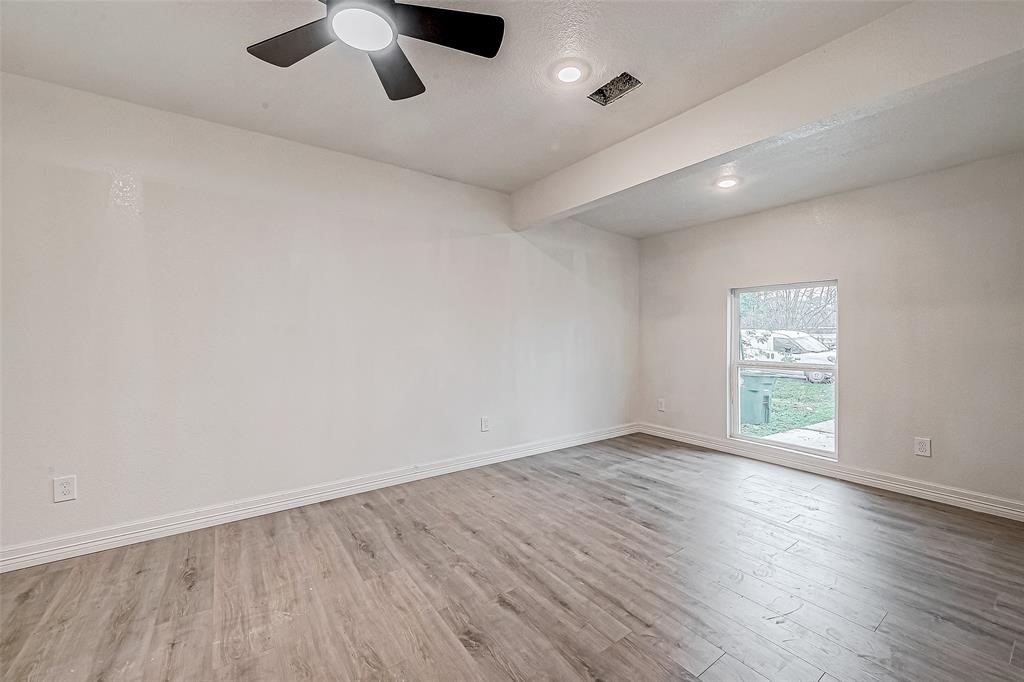 7010 South Hall Street Houston, TX 77028 - Photo 9 of 33 an empty room with wooden floor and windows