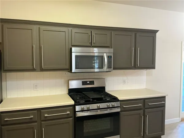 a kitchen with stainless steel appliances wooden cabinets and a stove top oven