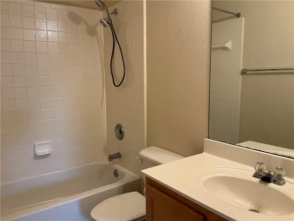 a bathroom with a sink vanity mirror and a bathtub