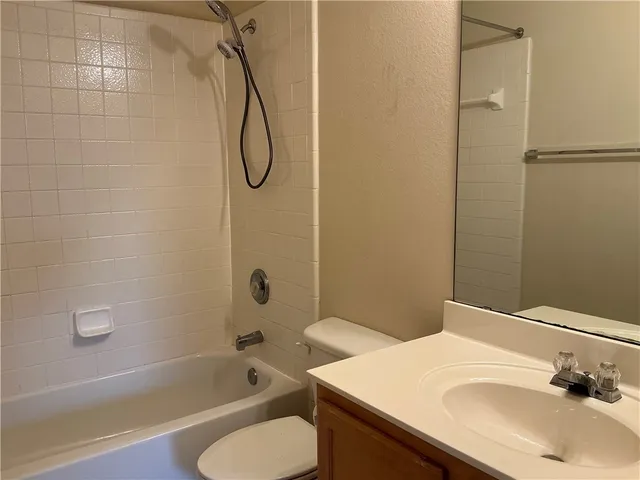 a bathroom with a sink vanity mirror and a bathtub