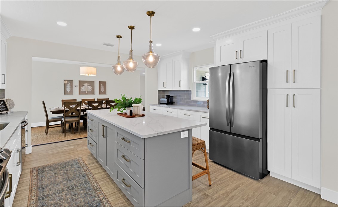 7989 143rd Street Sebastian, FL 32958 - Photo 11 of 30 a kitchen with stainless steel appliances a refrigerator a sink a stove a center island and furniture