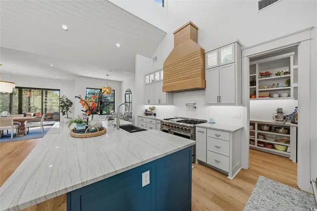 a kitchen with sink stove and cabinets