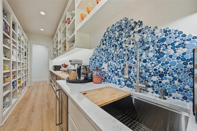 a kitchen with stainless steel appliances kitchen island a stove a chimney a sink and cabinets