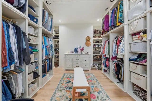 a view of walk in closet with clothes and shoes