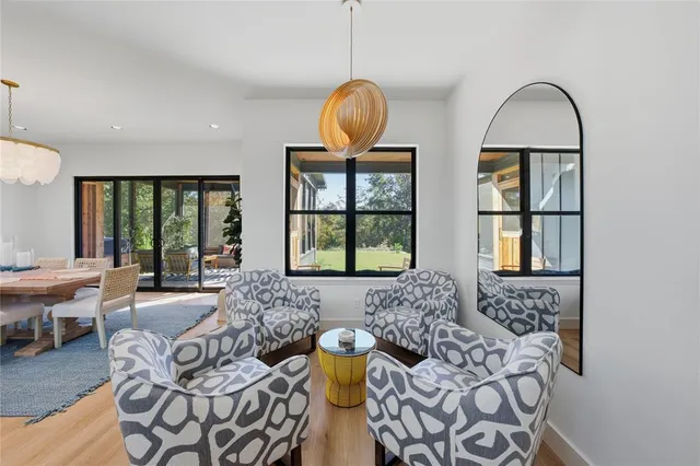 a living room with furniture two window and a chandelier