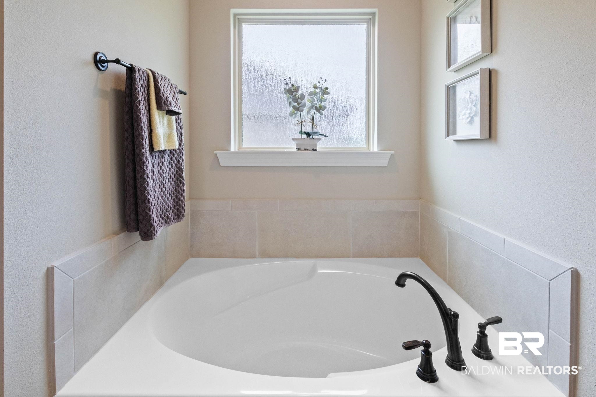 22244 Hibiscus Circle Foley, AL 36535 - Photo 45 of 51 Built-in soaking tub with dark bronze fixtures, surrounded by light-toned wall tile