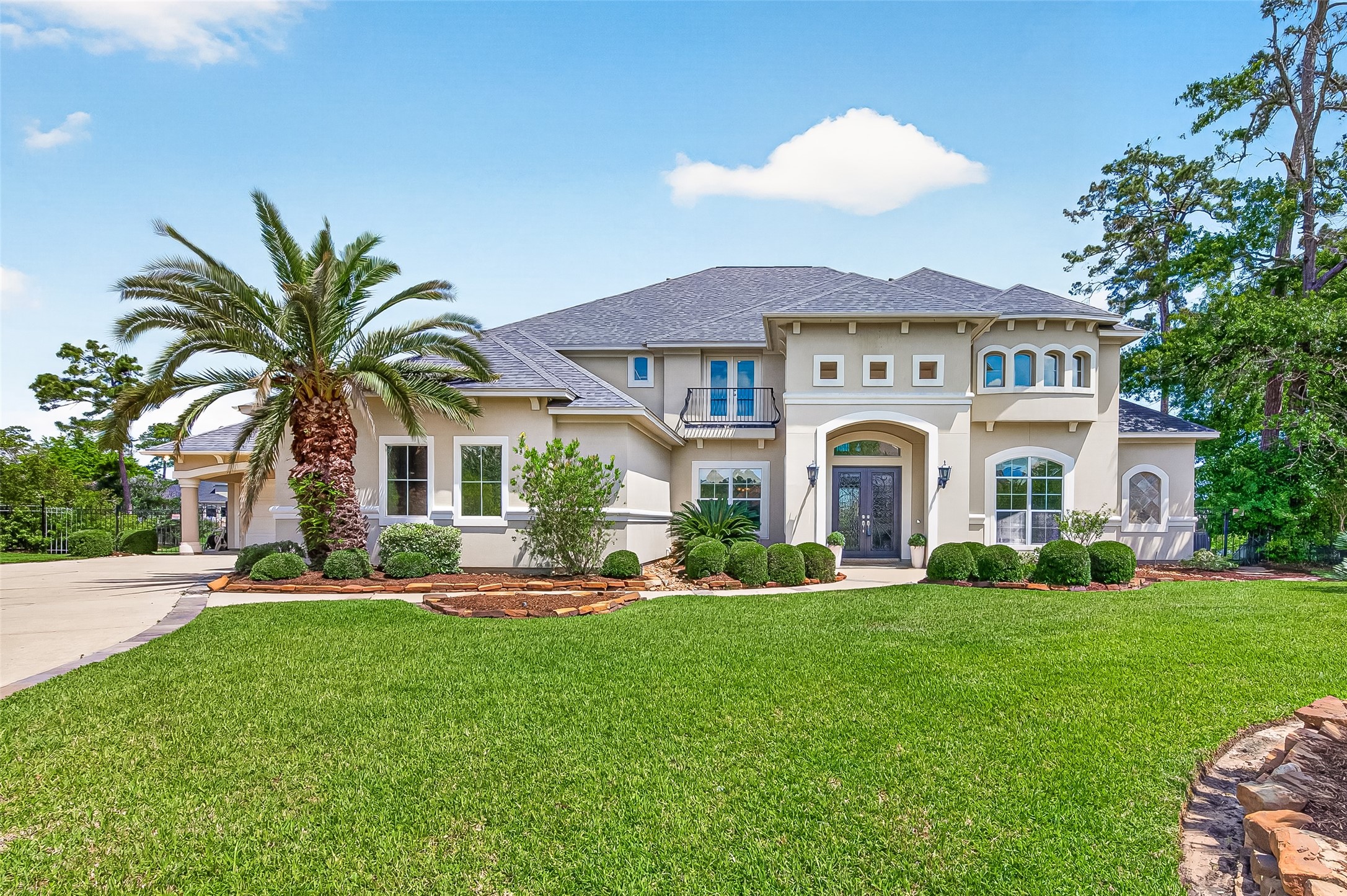 25626 Windy Isle Court Spring, TX 77389 - Photo 2 of 45 This elegant two-story home features a stucco exterior with a welcoming entrance, large windows and a spacious driveway leading up to two garages, with room for four cars in total.