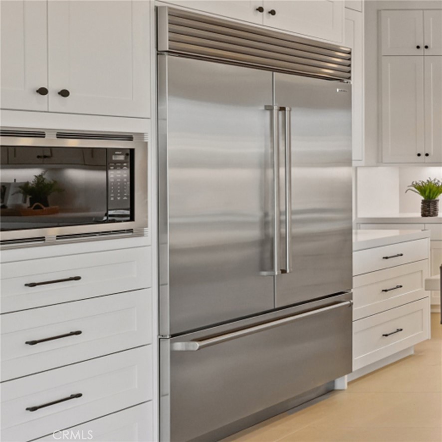 4971 Rideline Road Yorba Linda, CA 92887 - Photo 3 of 33 a kitchen with white cabinets and stainless steel appliances