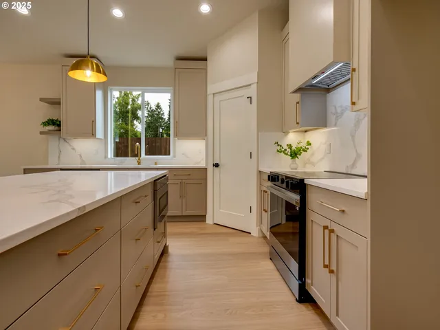 a kitchen with kitchen island a counter top space a sink stainless steel appliances and a window