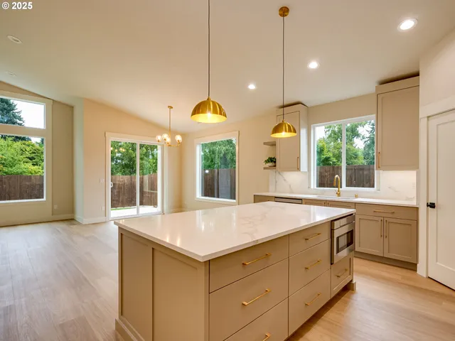 a large kitchen with kitchen island a sink stainless steel appliances and cabinets