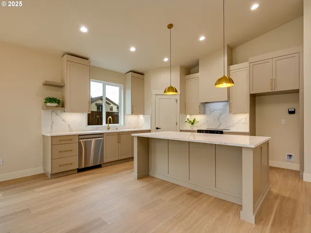 a large kitchen with stainless steel appliances kitchen island granite countertop a sink and cabinets