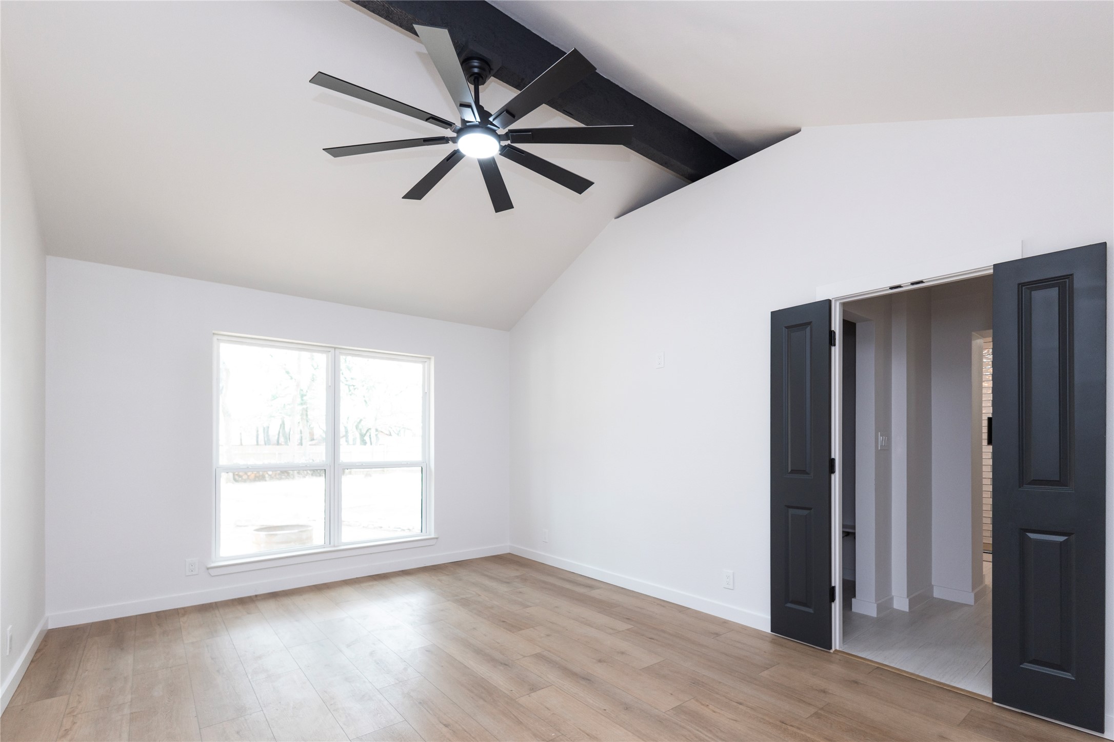 205 Bello Circle Georgetown, TX 78628 - Photo 25 of 36 A tranquil primary bedroom with vaulted ceilings and a statement modern fan, bathed in natural illumination.