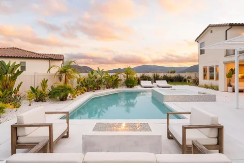 a view of a patio with swimming pool and a chairs