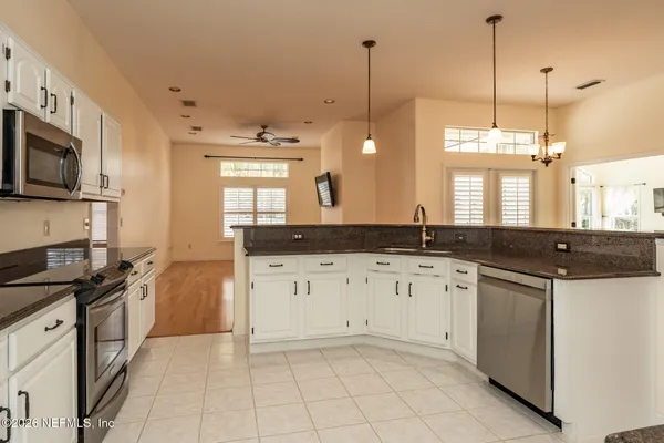 a kitchen with granite countertop a sink a stove and cabinets
