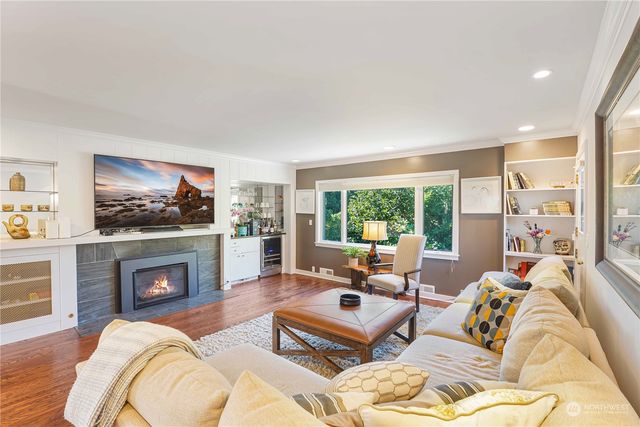 a living room with furniture large window and a fireplace