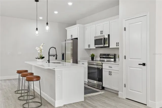 a kitchen with stainless steel appliances a stove sink microwave and cabinets