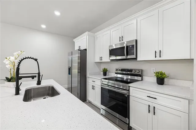 a kitchen with stainless steel appliances a sink a stove and microwave