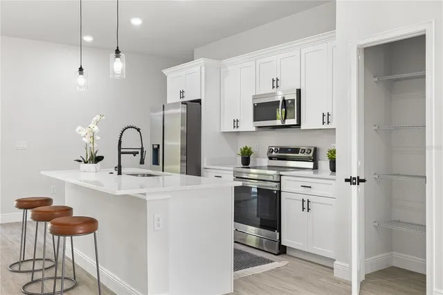 a kitchen with stainless steel appliances a microwave stove and cabinets