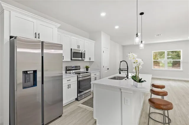 a kitchen with sink refrigerator and microwave