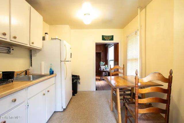a kitchen with sink refrigerator and cabinets