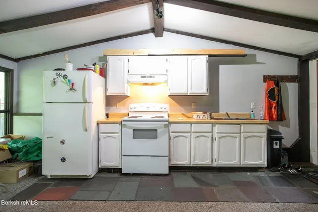 a kitchen with white cabinets and white appliances