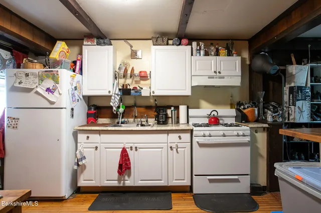 a kitchen with white cabinets and white appliances
