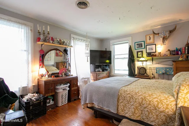 a bedroom with a bed and a flat tv screen on the dresser