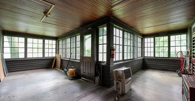 a view of an empty room wooden floor and furniture