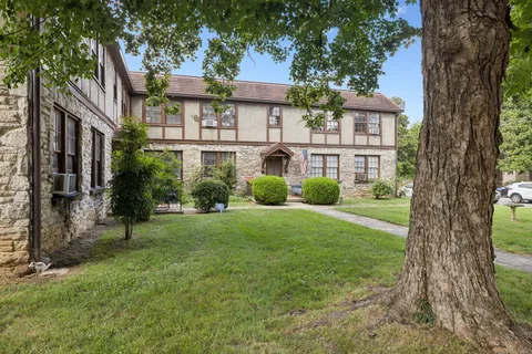 a view of a brick house with a large windows and a yard