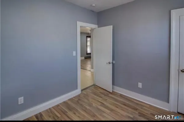 an empty room with wooden floor and closet