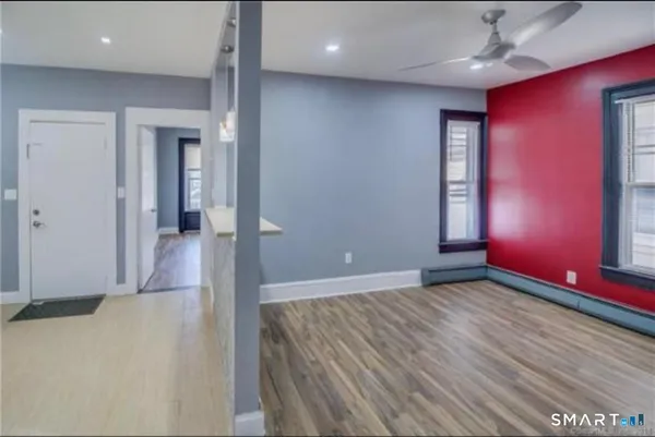 an empty room with wooden floor and windows