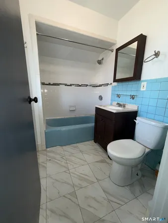 a bathroom with a sink a toilet and mirror