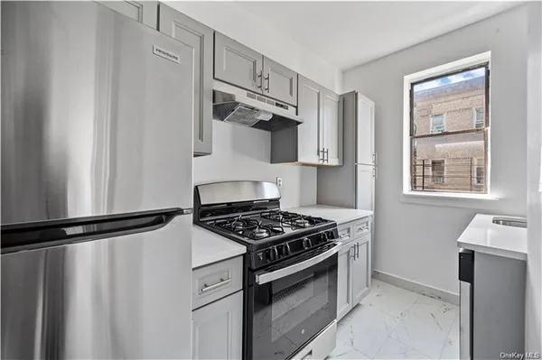 a kitchen with stainless steel appliances a refrigerator and a stove top oven