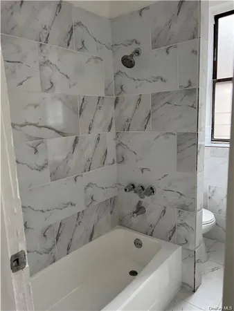 a bathroom with a bathtub and toilet