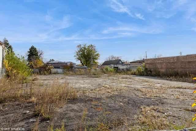 a view of a dry yard with wooden fence