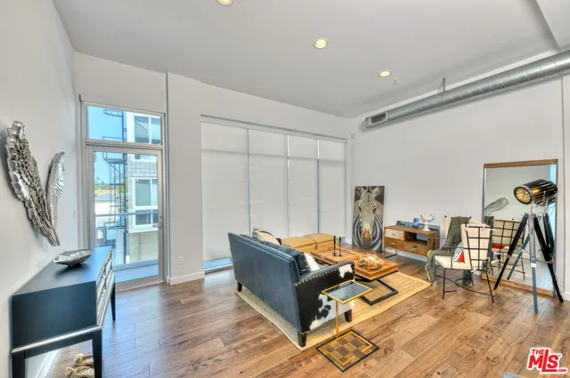a living room with furniture a wooden floor and next to a window