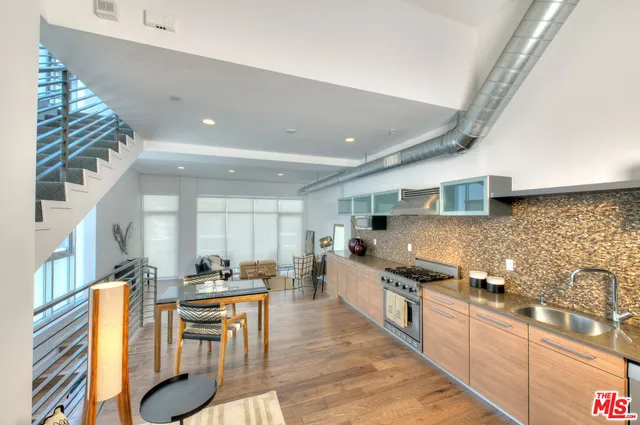 a kitchen with stainless steel appliances granite countertop a sink and a refrigerator