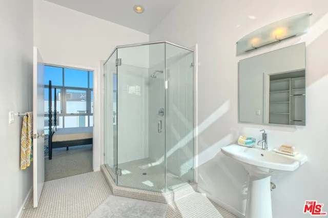 a bathroom with a sink shower and a mirror
