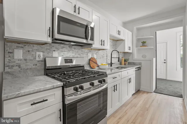 a kitchen with stainless steel appliances granite countertop a stove and a microwave