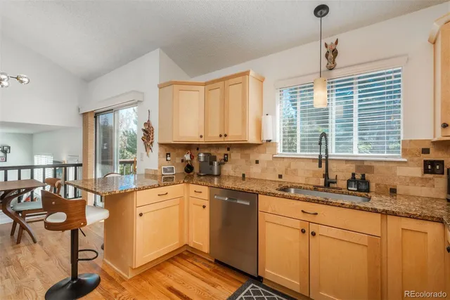 a kitchen with granite countertop a sink cabinets and window