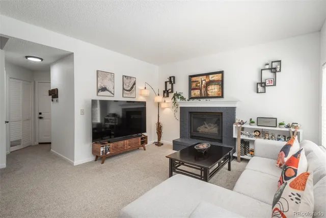 a living room with furniture a fireplace and a flat screen tv