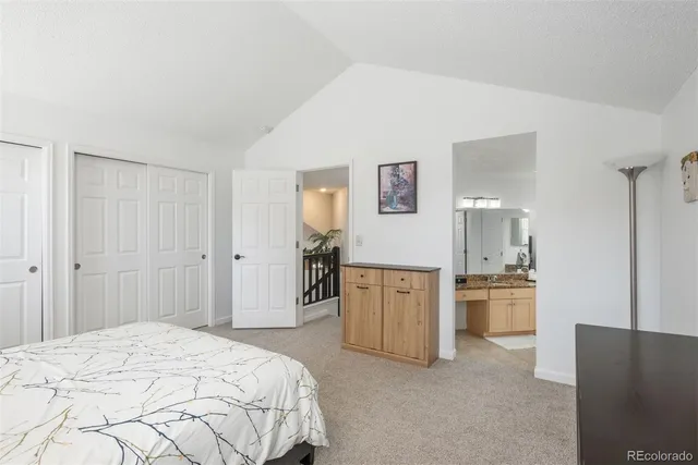 a spacious bedroom with a bed and a refrigerator