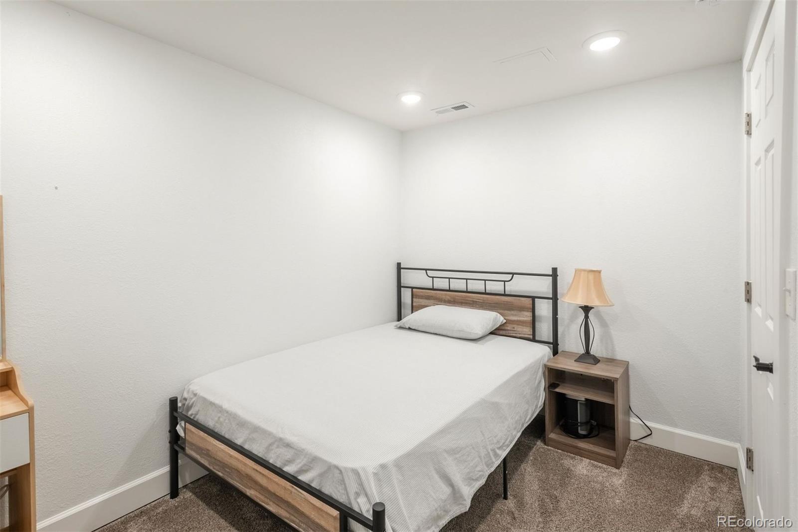 9222 Buttonhill Court Highlands Ranch, CO 80130 - Photo 37 of 44 a bedroom with a bed and a night stand