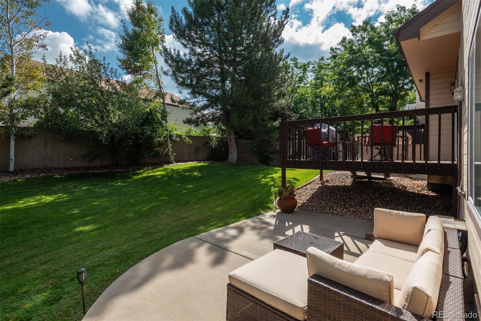 9222 Buttonhill Court Highlands Ranch, CO 80130 - Photo 42 of 44 a view of a backyard with couches plants and large tree