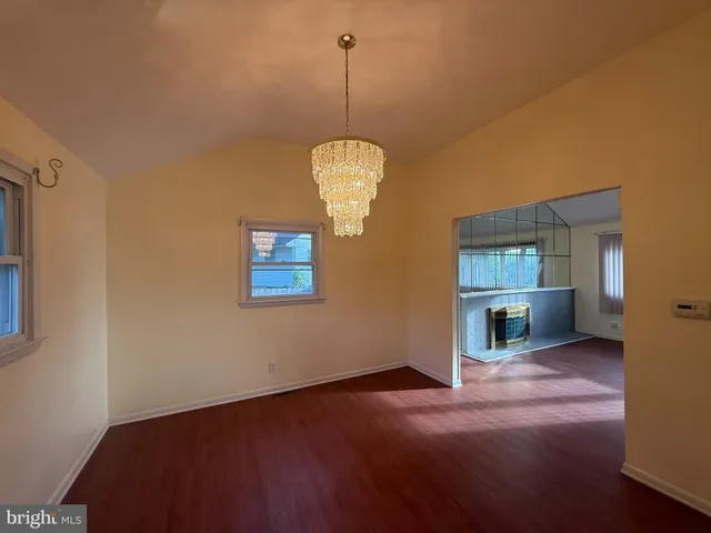 a view of a room with a hanging light and kitchen