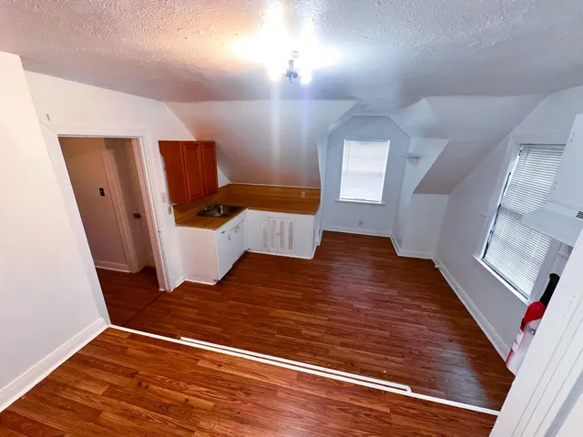 a view of an empty room with wooden floor
