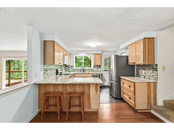 a kitchen with stainless steel appliances granite countertop a stove a sink dishwasher and a microwave