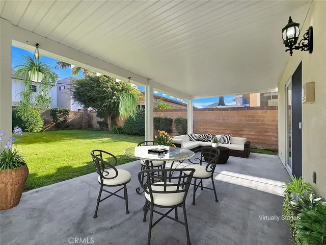 a view of a patio with a table chairs and garden